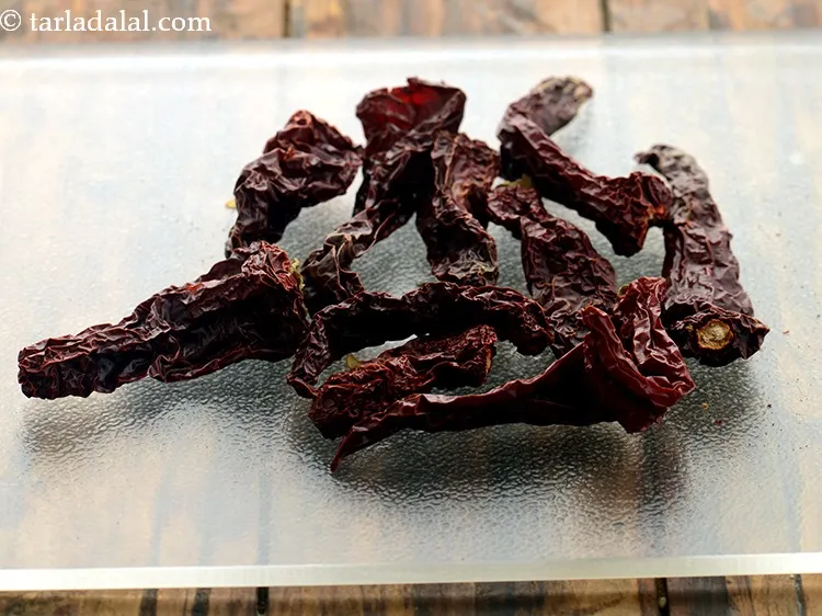 Step 20 – Add 5&nbsp;<a href="https://www.tarladalal.com/glossary-whole-dry-kashmiri-red-chillies-kashmiri-mirch-kashmiri-lal-mirch-332i">whole dry kashmiri red chillies</a>&nbsp;, broken into pieces.