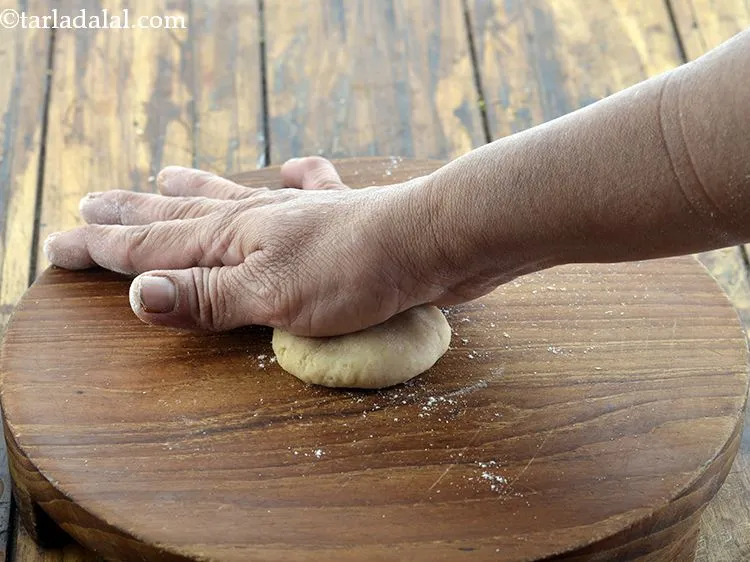 Step 25 – Take a portion of the dough and flatten it between your palms.