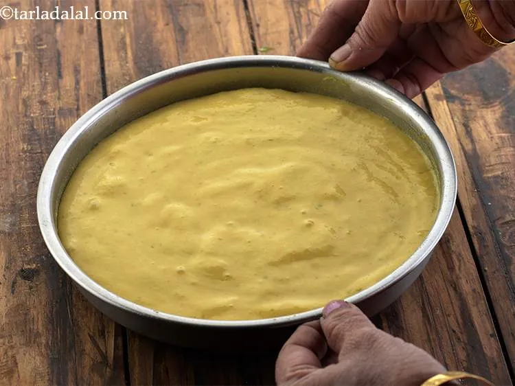 Step 13 – Pour the mixture immediately to a greased 175 mm. (7&quot;) diameter thali and spread evenly …