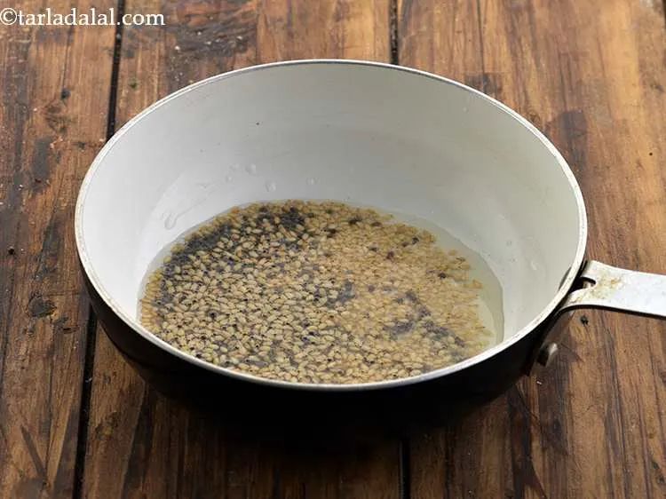 Step 16 – When the seeds crackle, add the sesame seeds.