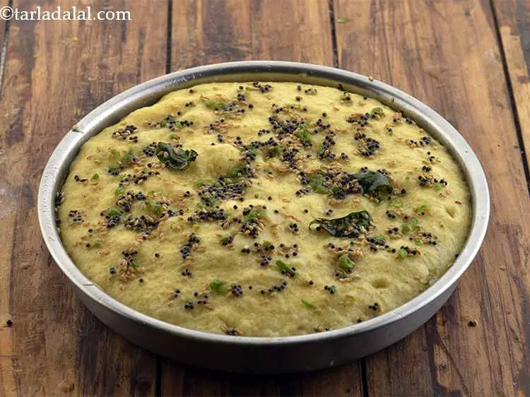 Step 20 – Pour the tempering evenly over the prepared dhoklas with the help of a spoon.