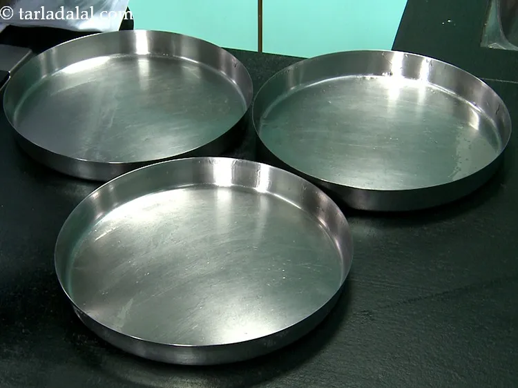 Step 2 – To make&nbsp;<strong>besan khandvi</strong>, firstly grease 3 thalis (10&rdquo; diameter each) lightly with oil on the …