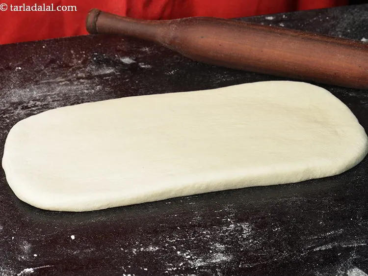 Step 11 – Place the dough on it and roll it using a thick rolling pin into a …