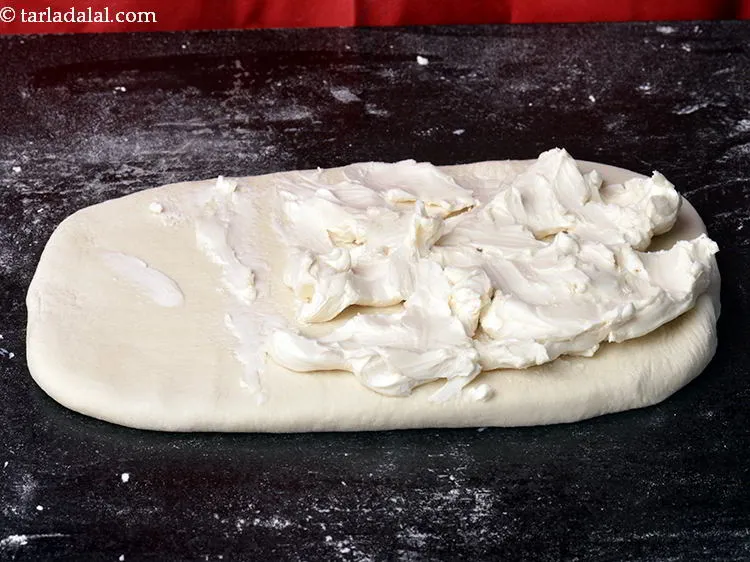 Step 12 – Spread margarine evenly on two-third portion of the rectangle with your hands in such a …