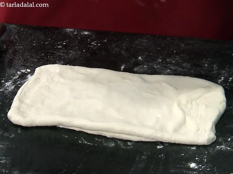 Step 16 – Again dust the flat surface with a little plain flour. Turn the dough 90 degrees …