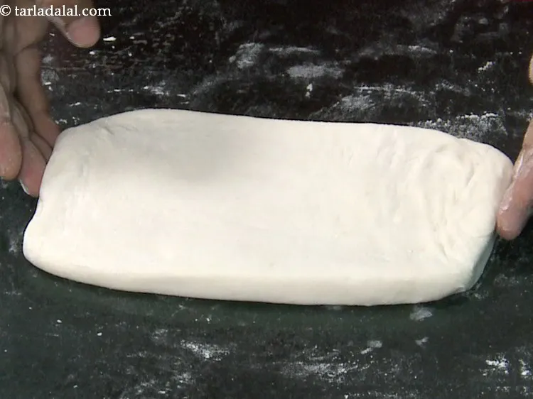 Step 28 – Dust the flat surface once again with a little plain flour, place the dough on …