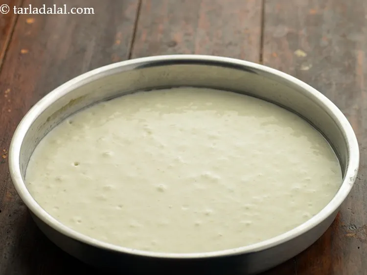 Step 15 – Pour one portion of the batter immediately into the greased thali and shake the thali …