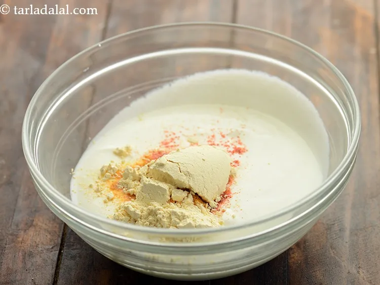 Step 11 – Add besan. It will thicken the curd gravy.