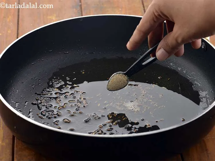 Step 7 – When the seeds crackle, add the asafoetida.