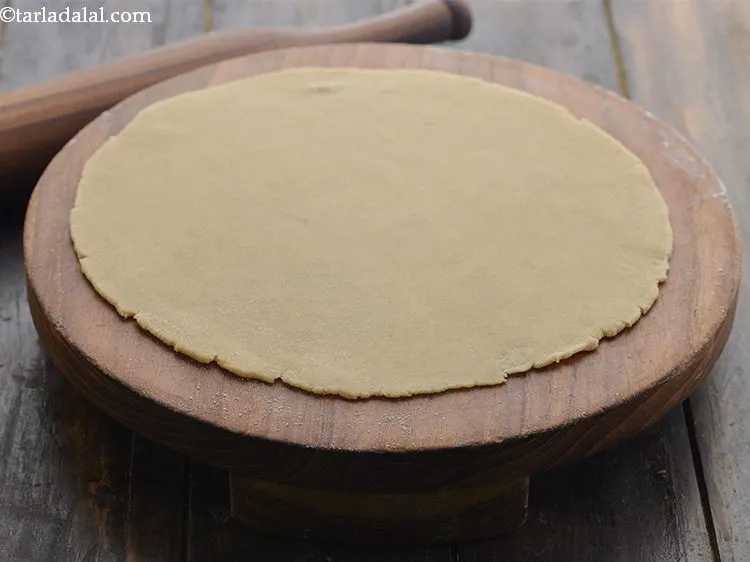 Step 11 – Roll a portion of the dough into a 200 mm. (8&rdquo;) diameter circle using a …