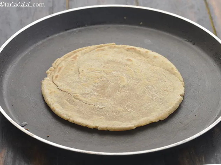 Step 20 – Heat a non-stick tava (griddle) and place the rolled lachha paratha over it.