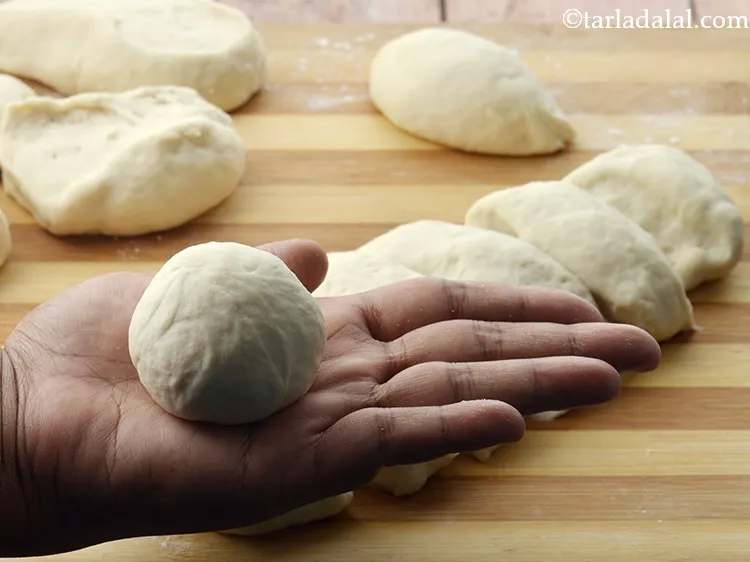Step 26 – Tuck the edges underneath towards the center and roll each portion of dough into a …