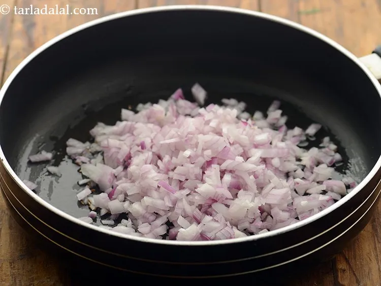 स्टेप 21 – जब जीरा चटक जाएं, तो प्याज डालें।