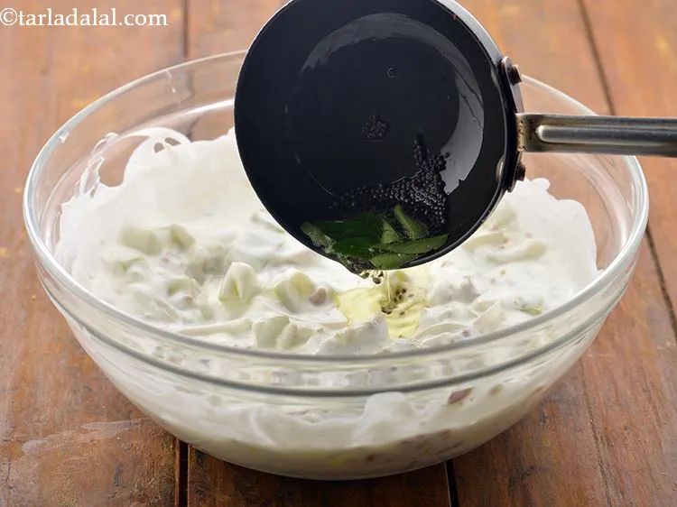 Step 21 – Pour this tempering over the&nbsp;<strong>Lauki ka Raita recipe (Dudhi Raita) or&nbsp;</strong>curds-bottle gourd mixture and mix …