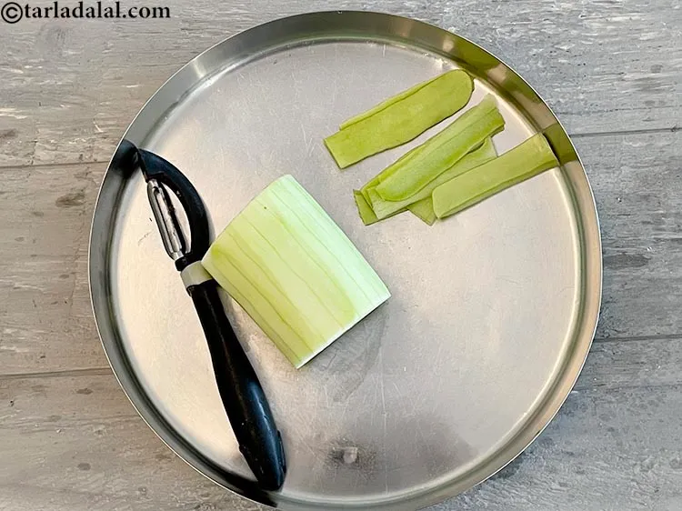 Step 8 – Wash and then peel the skin off the lauki (bottlegourd).