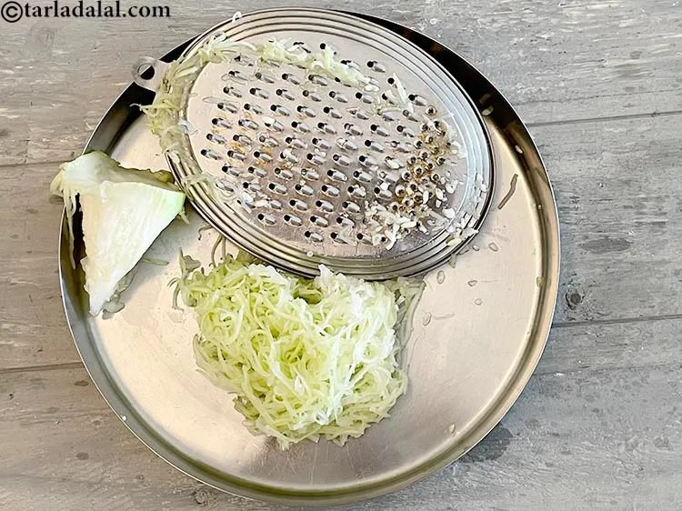 Step 9 – Hold a vegetable grater in one hand and the bottle gourd on the other. Starting …