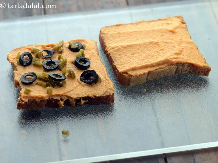 Step 20 – Sprinkle 1 tsp of black olives on one toast.