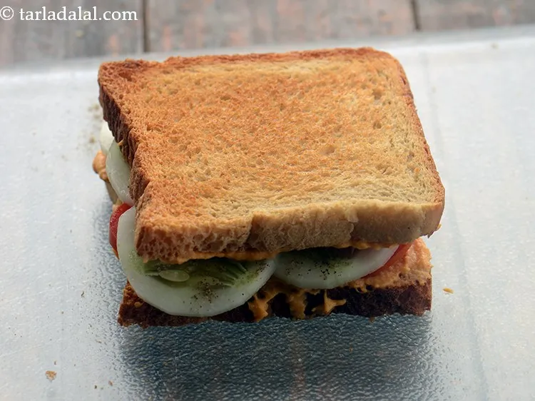 Step 25 – Cover it with another slice with the spicy garlic hummus side facing downwards and press …