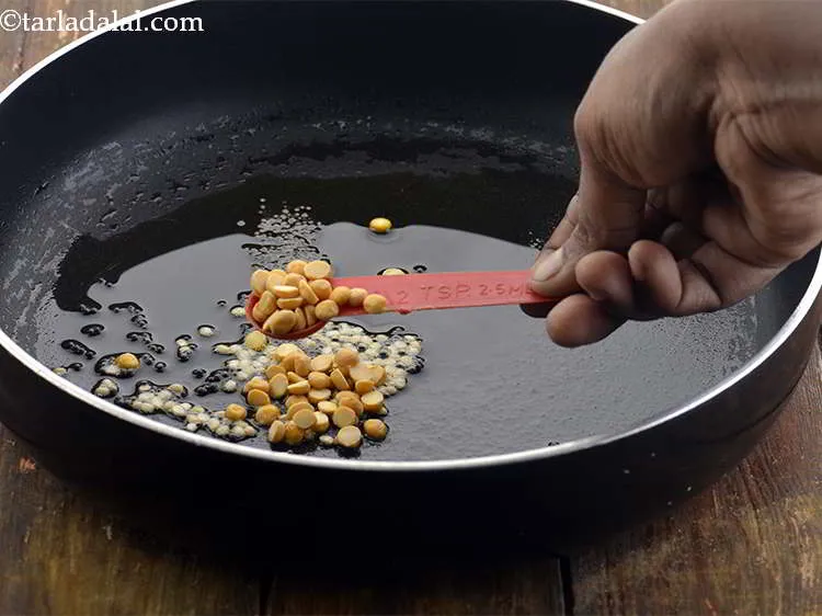 स्टेप 11 – साथ ही, चना दाल डालें। आप मूंगफली और काजू भी …