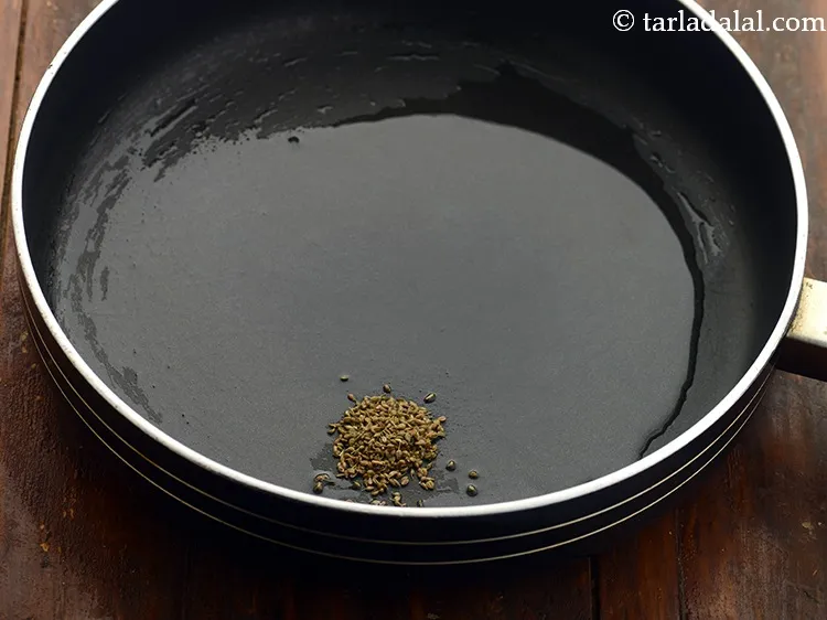 Step 3 – Once the oil is hot, add the carom seeds and allow them to crackle.