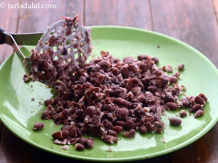 Step 21 – Transfer to plate and coarsely crush the rajma using a potato masher.