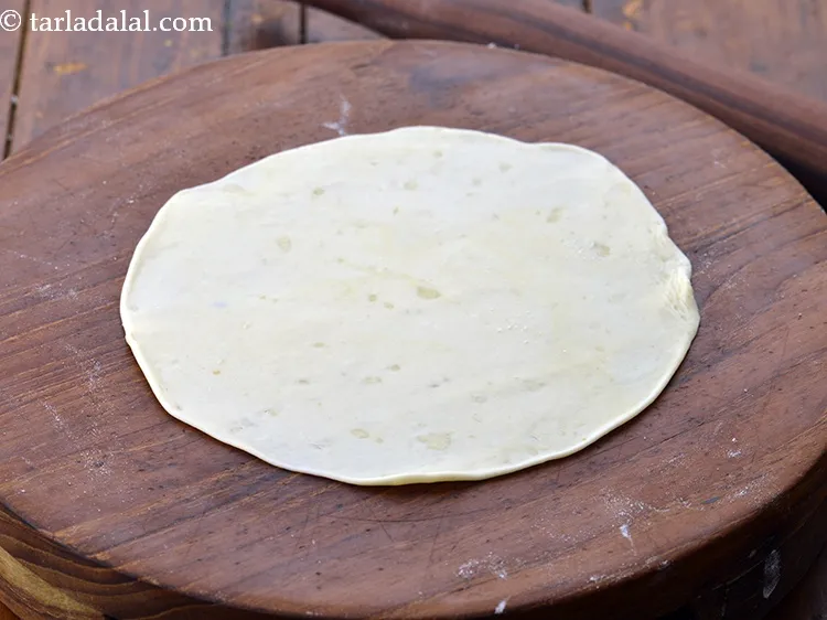 Step 51 – Roll a portion of the dough into 150 mm. (6&rdquo;) diameter circle using a little …
