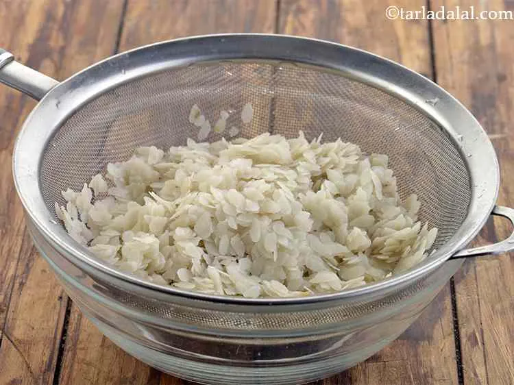 Step 20 – For <strong>Maharashtrian style batata poha</strong>. Place the poha in a strainer, toss well to drain …