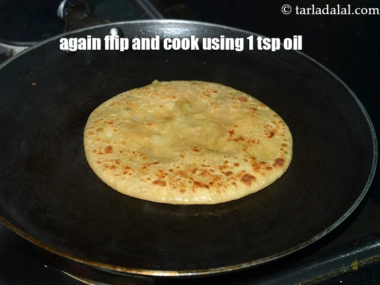 Step 43 – Again flip the aloo paratha and smear more&nbsp;1 tsp&nbsp;<a href="https://www.tarladalal.com/glossary-oil-671i">oil</a> or ghee&nbsp;over it and let …