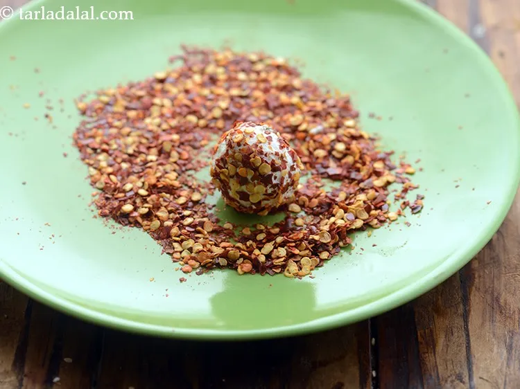 स्टेप 6 – रोल किये हुए पनीर बॉल को मिर्च के फ्लैकस् पर …