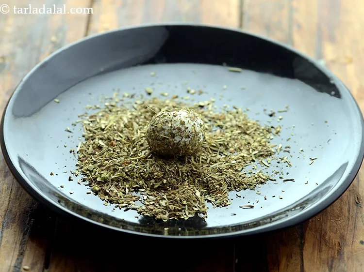 Step 8 – Place the rolled <strong>paneer ball in the mixed herbs</strong>. Make sure it is evenly coated …