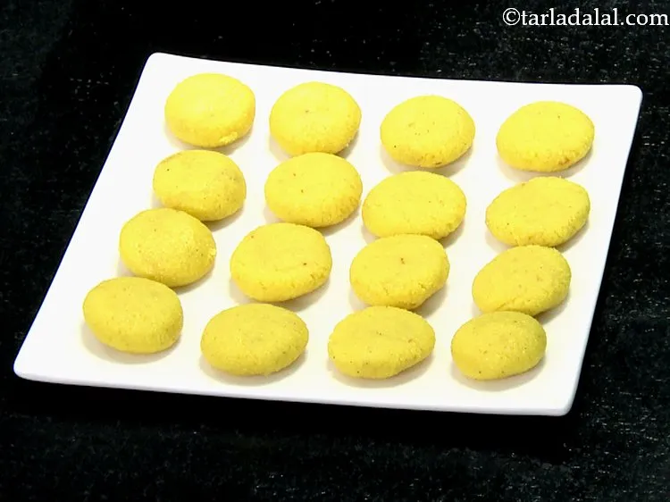 Step 17 – &nbsp;Shape each portion of the <strong>Malai peda</strong> in between your palms into a flat round …