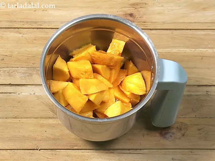 Step 7 – Roughly chop the mangoes. Add 2 cups&nbsp;roughly&nbsp;<a href="https://www.tarladalal.com/glossary-chopped-mango-803i">chopped mangoes</a>&nbsp;into a mixer jar.&nbsp;