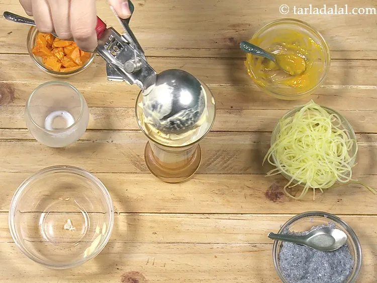 Step 16 – Add 1 scoop of <a href="https://www.tarladalal.com/mango-ice-cream-3985r">mango ice-cream</a>.