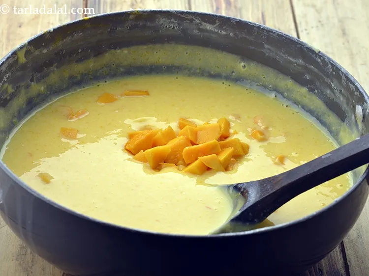 स्टेप 25 – १/२ कप <a href=""https://www.tarladalal.com/glossary-chopped-mango-hindi-803i"">कटा हुआ आम</a> डालें और धीरे से …