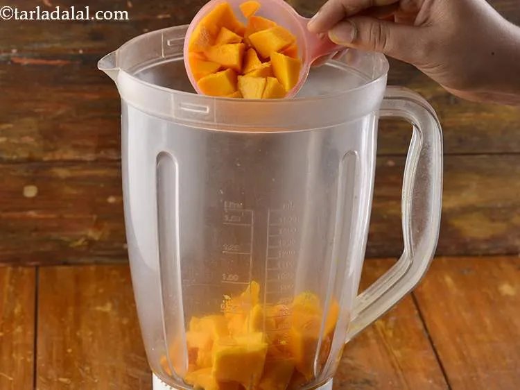 Step 4 – Take a deep mixer jar and put the mangoes into it.