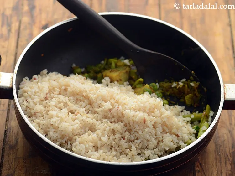 Step 24 – Add the brown rice. <strong>Traditional Masala Bhaat</strong> makes use of white rice.