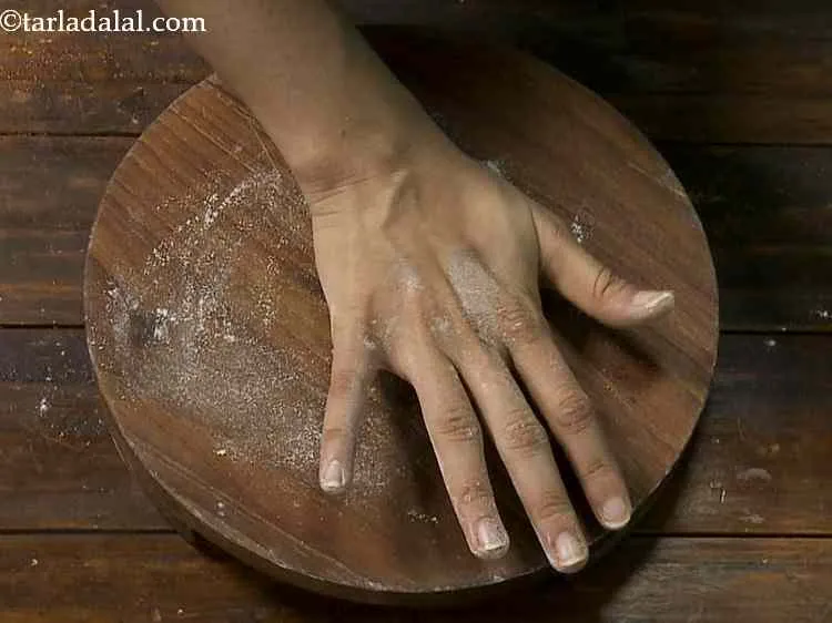 Step 11 – Take one portion of dough, roll it in between your palms and flatten it on …