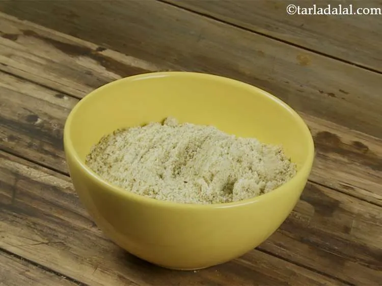 स्टेप 9 – मिक्सर जार का ढक्कन खोलें और दरदरे पाउडर को एक …