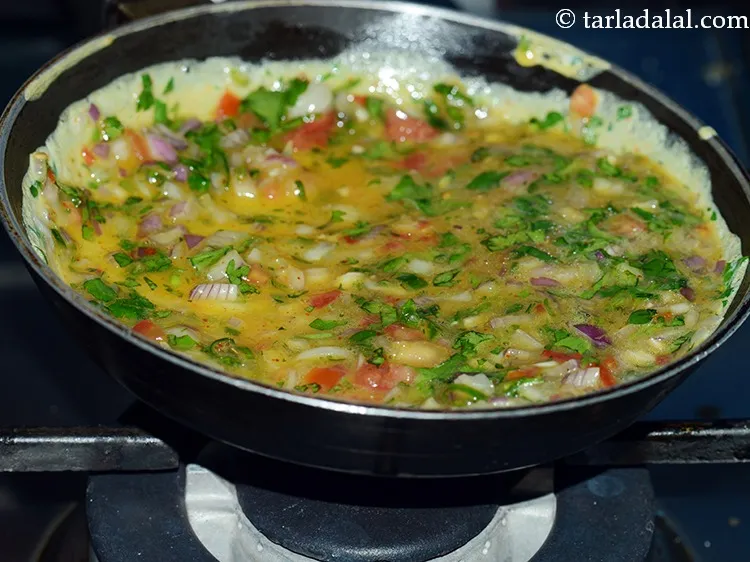 स्टेप 14 – आधे अंडे का मिश्रण डालें और पैन को थोड़ा हिलाकर …