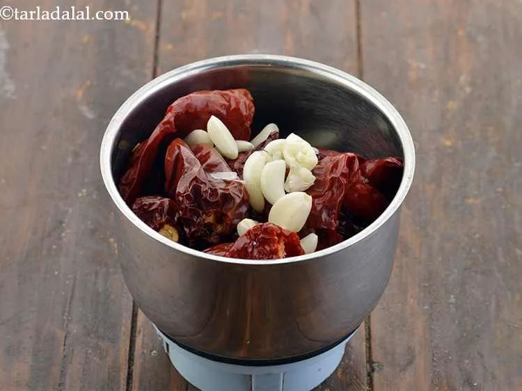 Step 14 – Transfer the chillies to a small mixer grinder and add roughly chopped 1 tbsp of …