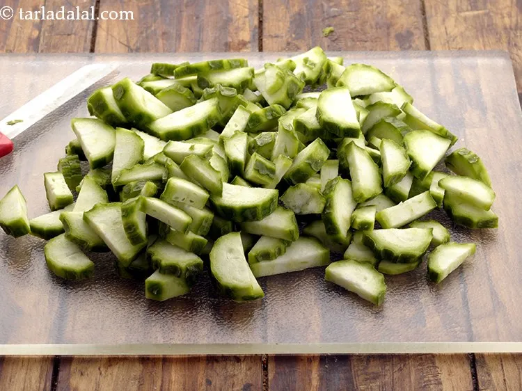 Step 4 – Place the turai on a chopping board and thickly slice it. Keep aside.