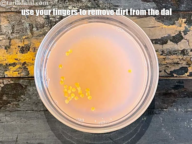 Step 5 – Use your fingers to remove dirt from the dal. You can see the water turning …