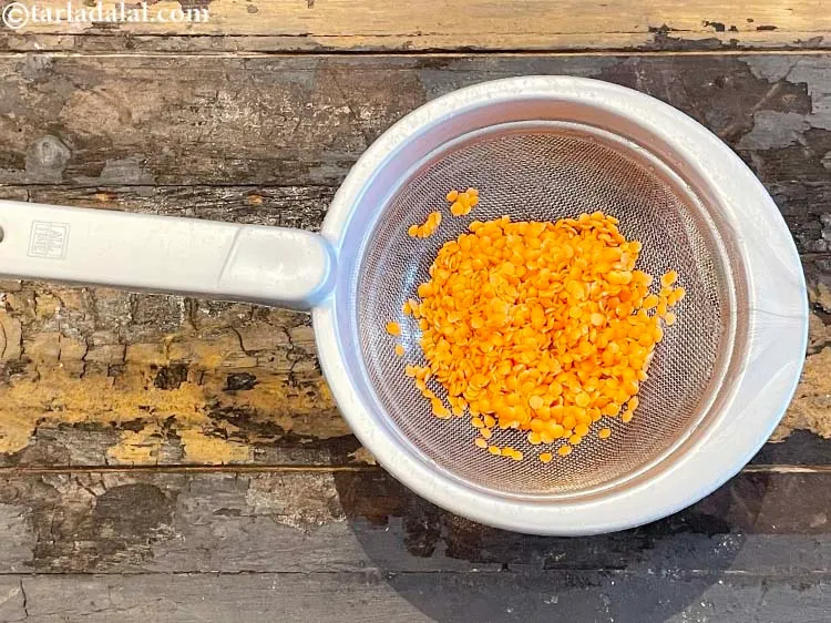 Step 6 – Use a sieve and drain out the water. <strong>The&nbsp;masoor (split red lentil) dal&nbsp;is&nbsp;washed and drained.</strong> …