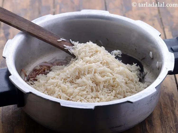 स्टेप 12 – चावल डालें। <strong>मटर पुलाव</strong> को थोड़ा अलग स्वाद देने के …