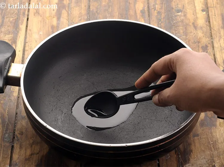 Step 23 – Now for tempering of the <strong>matki sabzi recipe</strong>, heat oil in a deep non-stick pan.&nbsp;