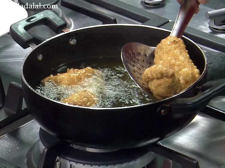 Step 53 – Frying on a medium flame is absolutely necessary to evenly browned <strong>mawa karanji</strong>.&nbsp;