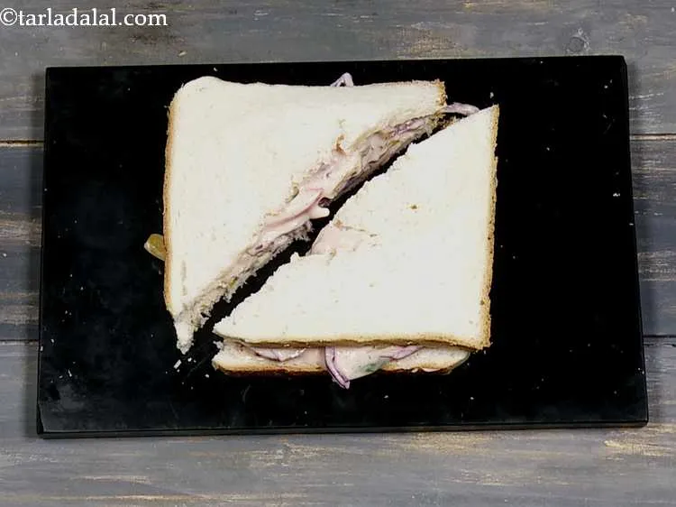 स्टेप 14 – <strong>मेयो वेज दही सैंडविच</strong> को तिरछे २ बराबर टुकड़ों में …