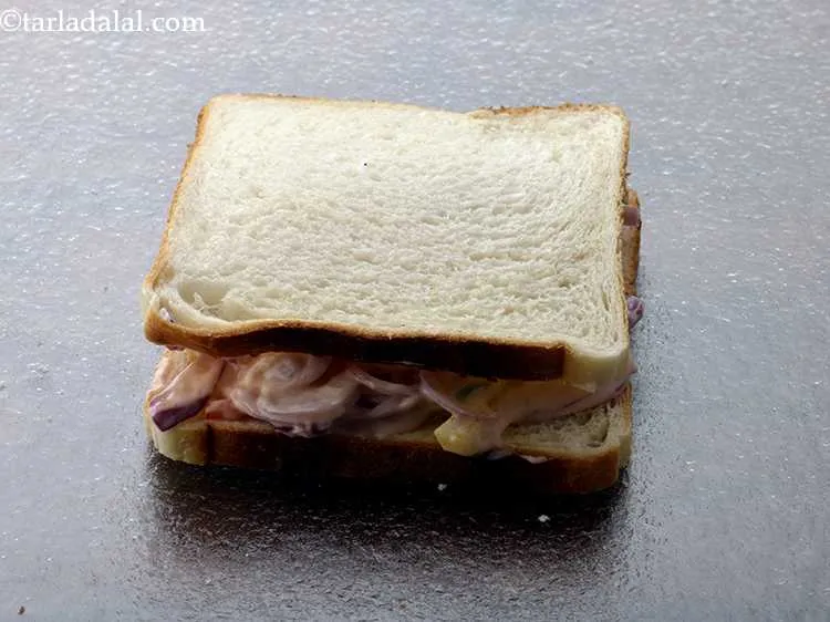 स्टेप 13 – दुसरी ब्रेड स्लाइस रखें, जिसमें मक्खन वाली साइड नीचे की …