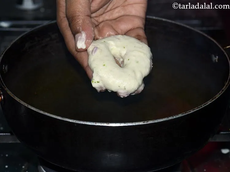 Step 30 – Press it gently and make thick round shaped vada. Make a hole in the centre …