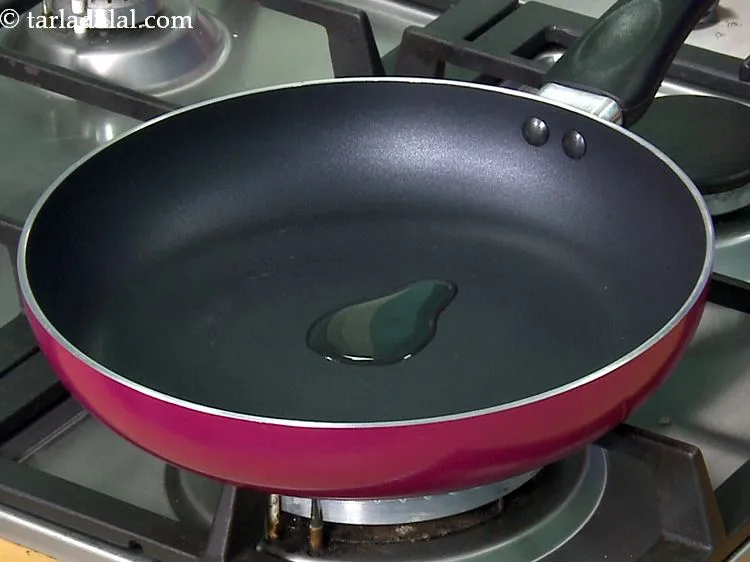 Step 27 – For the <strong>methi and moong sprouts stuffing</strong>, heat the oil in a broad non-stick pan.